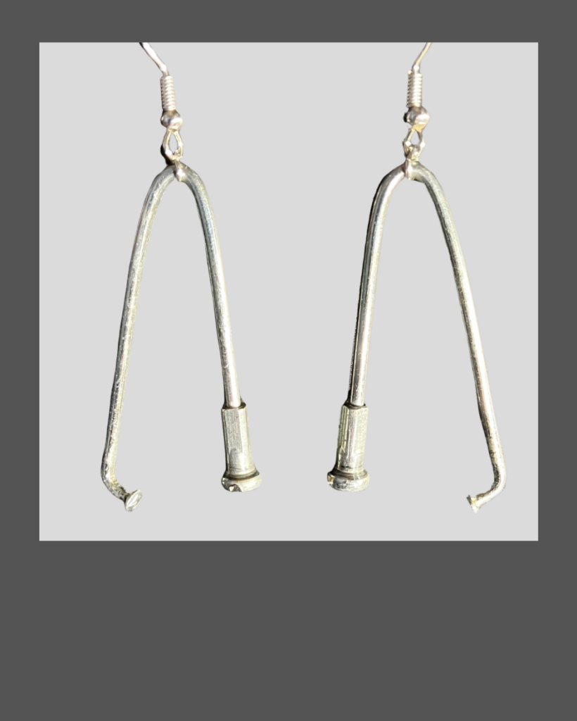 A pair of silver metal v-shaped earrings formed from bicycle spokes.